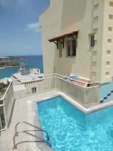 a swimming pool on the balcony of a building at Eleni Studios in Agios Nikolaos
