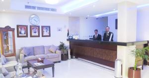 deux hommes debout dans un bar du hall dans l'établissement Al Jawhara Metro Hotel, à Dubaï