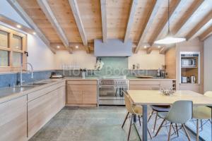 コンブルーにあるChalet Ravineの木製の天井、テーブルと椅子付きのキッチン