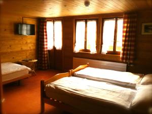 ein Schlafzimmer mit einem Bett und zwei Fenstern in der Unterkunft Auberge de la poste in Les Diablerets