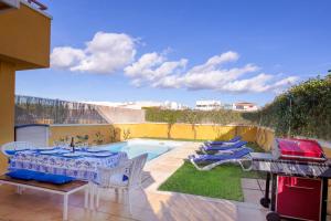 un patio con tavolo, sedie e piscina di Villa Isabel a Playa de Palma