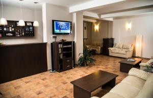 a living room with a couch and a tv at Pensiunea Carmen - Bikers Friendly Nest in Sibiu