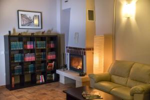 a living room with a couch and a book shelf with books at Pensiunea Carmen - Bikers Friendly Nest in Sibiu