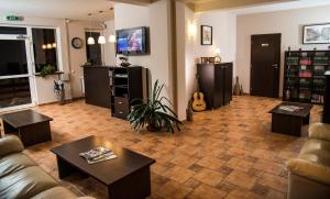 a living room with a couch and tables and a guitar at Pensiunea Carmen - Bikers Friendly Nest in Sibiu