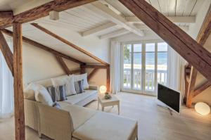 ein Wohnzimmer mit einem Sofa und einem TV in der Unterkunft Meerhaus Niendorf in Niendorf