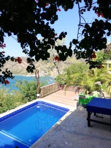 a blue swimming pool with a view of the water at Hostal Casa Horizonte in Taganga