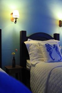 1 dormitorio con 1 cama con pared azul en Pousada do Cais, en Paraty