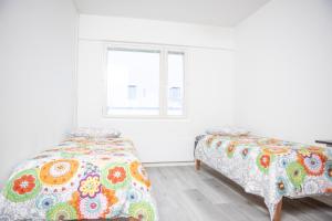 a bedroom with two beds and a window at Riverside Residences in Rovaniemi