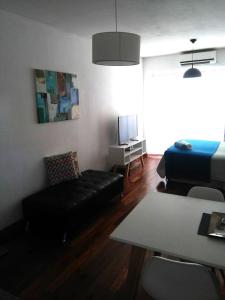 sala de estar con sofá negro y cama en M & C Suites en Buenos Aires