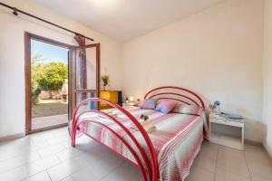 a bedroom with a bed with a red frame and a window at AffittaSardegna-Bilo Grosseto in San Teodoro