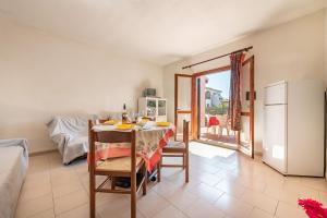 a dining room with a table and a refrigerator at AffittaSardegna-Bilo Grosseto in San Teodoro