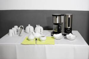 a counter top with a coffee maker and tea cups at Gracious Lodge in Burgersfort