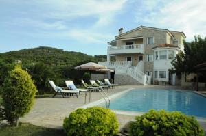 a villa with a swimming pool and a house at Bella Villa in Vaia