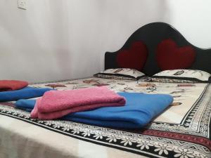 Una cama con mantas y almohadas. en Misty Mount Homestay, en Ella