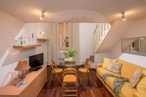 ein Wohnzimmer mit einem gelben Sofa und einem Tisch in der Unterkunft Navona White Apartment in Rom