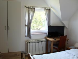 a bedroom with a bed and a desk and a window at LONJSKI DVORI in Kutina