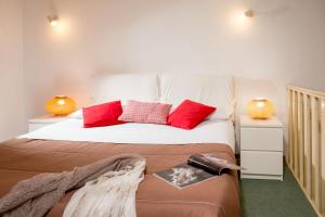 - une chambre avec un grand lit et des oreillers rouges dans l'établissement Navona White Apartment, à Rome