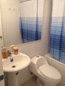 een badkamer met een wit toilet en een wastafel bij Condominio Parquemar!!! in El Tabo