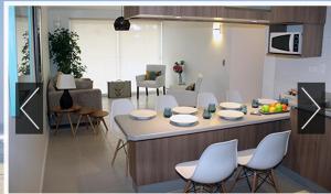 a living room with a table and chairs and a kitchen at Condominio Parquemar!!! in El Tabo