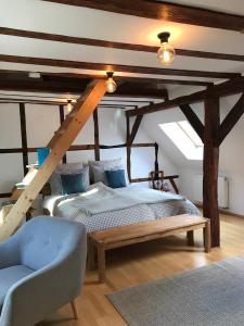 a bedroom with a wooden bed and a chair at Fuxbau in Neustadt an der Weinstraße