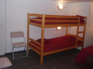 a bedroom with two bunk beds and a chair at L'ancolie in Orelle