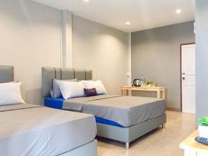 a bedroom with two beds and a table at R9 Bangkok in Bangkok