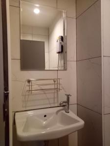 ein Bad mit einem Waschbecken und einem Spiegel in der Unterkunft R9 Bangkok in Bangkok