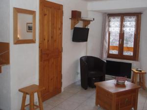 a living room with a wooden door and a table at L'ancolie in Orelle