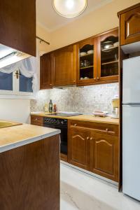 a kitchen with wooden cabinets and a black stove at Chic flat in Kolonaki next to American Embassy in Athens