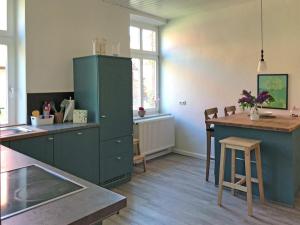 eine Küche mit einem grünen Schrank und einem Tisch in der Unterkunft Ferienwohnung Am Sod - Familie Hennig in Rullstorf