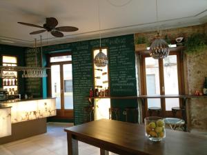 une salle à manger avec une table et un mur vert dans l'établissement Hospedium Hotel Cañitas Maite Boutique, à Casas Ibáñez