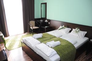 A bed or beds in a room at Green Hotel Budapest