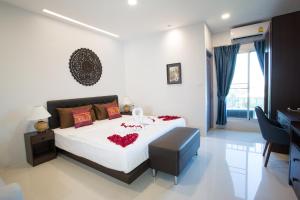 een slaapkamer met een groot wit bed en een bureau bij Pongsakorn Boutique Resort -SHA Extra Plus in Lat Krabang