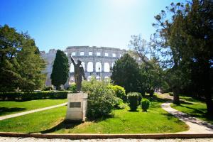a statue in a park with a building in the background at Downtown Apartments Pula in Pula