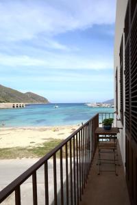 a balcony with a table and a view of the beach at La Praya in Favignana