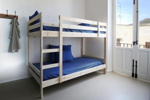 a bedroom with two bunk beds with blue sheets at La Praya in Favignana