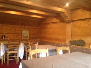 une salle à manger avec des murs en bois, des tables et des chaises dans l'établissement Auberge de la poste, aux Diablerets