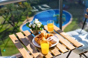 a table with a plate of pastries and two glasses of orange juice at Playa & Golf in Alicante