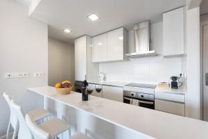 a white kitchen with white counters and white cabinets at Playa & Golf in Alicante +4 photos