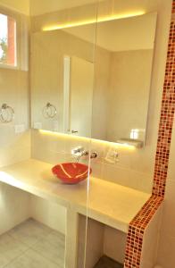 een badkamer met een rode wastafel en een spiegel bij Cabañas Las Troncas in Merlo