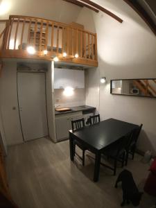 a kitchen and dining room with a table and a dog at Appartement Sainte Marie de Campan - Résidence le Vieux Village in Sainte-Marie-de-Campan