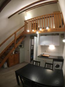 une cuisine et une salle à manger avec une table et un escalier dans l'établissement Appartement Sainte Marie de Campan - Résidence le Vieux Village, à Sainte-Marie-de-Campan