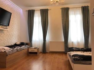 a living room with two beds and a tv at Pokoje nad Drzewiczką in Drzewica