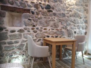un mur en pierre avec une table et des chaises en bois dans l'établissement Studio mistral, à Valence