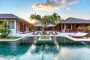 a villa with a swimming pool and a resort at La Villa Des Sens in Seminyak