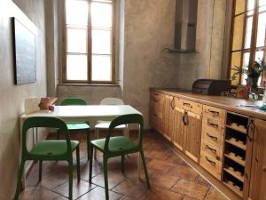 a kitchen with a table and four green chairs at Apartmány 83 in Horní Maršov