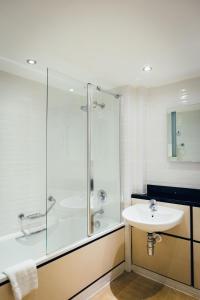 a bathroom with a glass shower and a sink at voco Letchworth Hall by IHG in Letchworth