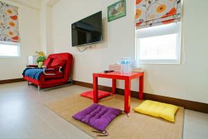 a living room with a red table and a red chair at Walk in the Wind Homestay in Taitung City