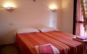 1 dormitorio con 1 cama con 2 almohadas en Agriturismo Cuile de Molino, en Porto Torres