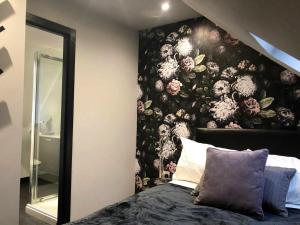a bedroom with a floral wall mural next to a bed at Boutique Loft Apartment in Dunkeld